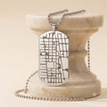 Back side of personalized map dog tag necklace with custom engraved text.