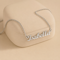 Angled view of polished personalized cursive name necklace on a jewelry display